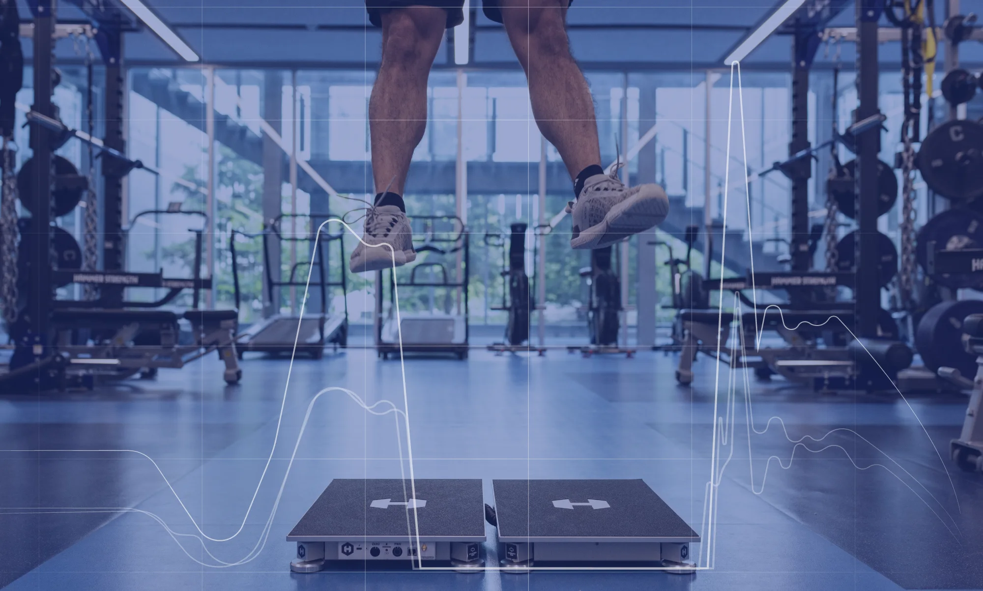 Athlete mid-jump over Hawkin Dual Wireless Force Plates, with the force-time trace overlaid